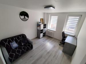 a living room with a couch and a desk at Sweet Apartament 6 osobowy in Płock