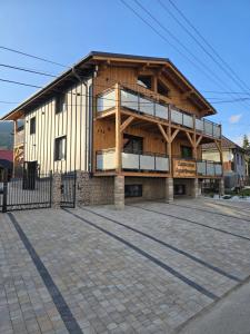 Un gran edificio de madera con un gran balcón. en Luxusný apartmán Karolína, en Telgárt