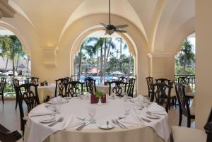 una sala da pranzo con tavoli, sedie e finestre di Occidental Caribe - All Inclusive a Punta Cana