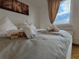 a white bed with towels on it with a window at Bliss Place, Komfort Apartment mit 2 Zimmern und Balkon in Toplage in Magdeburg