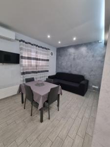 a living room with a table and a couch at Holiday Home B&M in Pozzallo