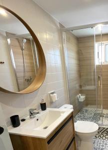 a bathroom with a sink and a toilet and a mirror at Apartamento El Sol in Piles
