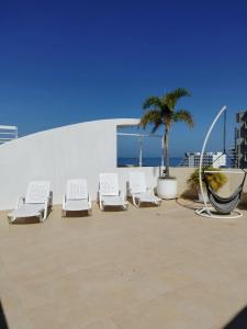 a group of lounge chairs and a palm tree at Apto Vista Mar 2 cuadras Playa, Jaccuzi BBQ Wifi Parqueadero y Ascensor 7 Piso in Santa Marta +38 photos