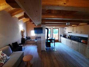 a living room and kitchen with a couch and a table at Tabià Su'n Coi in Alleghe