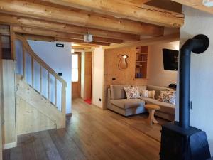 a living room with a wood stove and a couch at Tabià Su'n Coi in Alleghe