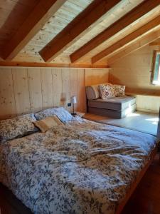a bedroom with a bed and a couch in a attic at Tabià Su'n Coi in Alleghe