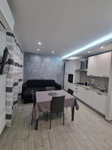 a living room with a table and a kitchen at Holiday Home B&M in Pozzallo