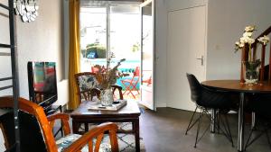 a living room with a table and chairs and a dining room at FLOREVA 22 entre Plage et Thalasso - Internet fibre in Concarneau