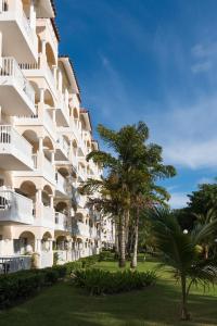a large white building with trees in front of it at Occidental Caribe - All Inclusive in Punta Cana