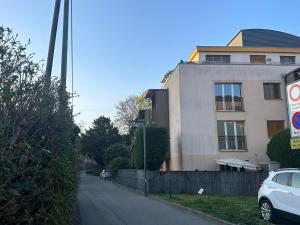 une voiture garée dans une rue à côté d'un bâtiment dans l'établissement Sunny Place Geneva 15 min Train, à Versoix