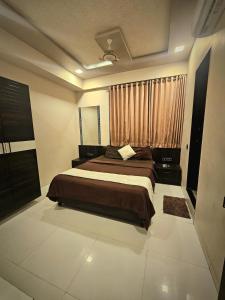 艾哈迈达巴德Hotel rk palace的带一张大床和一扇窗户的卧室