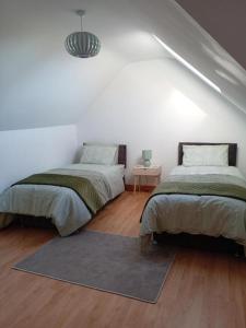 ダンドークにあるCharlestown bungalowのラグ付きの白い部屋のベッド2台 +9枚の写真