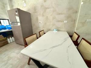 a room with a white table and chairs and a refrigerator at oceya in Magong