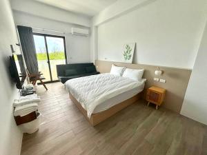 a bedroom with a bed and a couch and a television at oceya in Magong