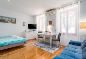 una camera da letto con un divano blu, una scrivania e un letto di Augustina Apartment a Rovigno (Rovinj)