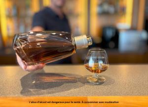 een persoon die een glas wijn uit een fles schenkt bij Hôtel Le Valois, Cognac Centre in Cognac