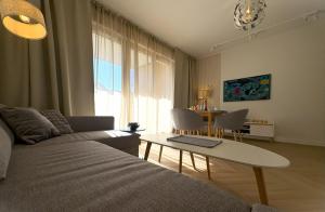 a living room with a couch and a table at Baltic Apartment White Diuna Supernovi in Gdynia