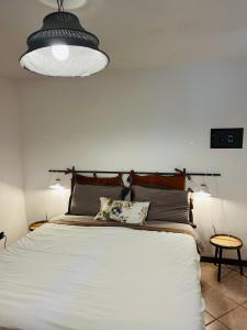 a bedroom with a large white bed with aendant light at Civico 7 in Clusane sul Lago