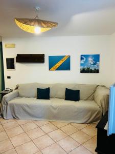 a couch in a living room with paintings on the wall at Civico 7 in Clusane sul Lago