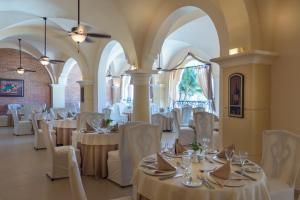 a dining room with white tables and chairs at Occidental Caribe - All Inclusive in Punta Cana
