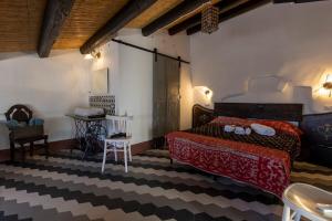 a bedroom with a large bed and a table at Le Cementine in Sorgono