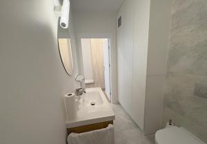 a white bathroom with a sink and a toilet at Baltic Apartment White Diuna Supernovi in Gdynia
