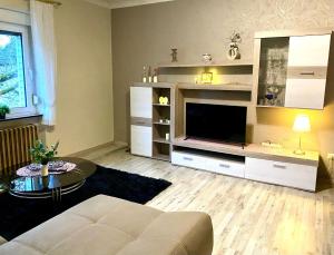 a living room with a couch and a television at Zum-Altbreitenfelderhof in Altbreitenfelderhof
