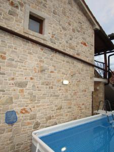 a brick building with a swimming pool next to it at Villa Sartori in Sarići