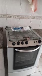 a stove top oven with a pan on top of it at Apto Pé na Areia in São Vicente