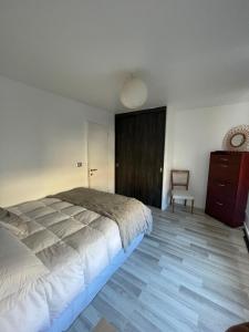 a bedroom with a bed and a dresser and a chair at Dormitorio Cerro Cárcel Parque Cultural in Valparaíso