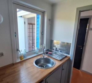 a bathroom sink with a mirror and a window at Isikkivik Cottage in Narsaq