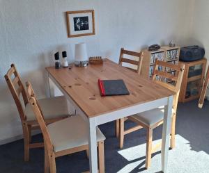 a wooden table with chairs and a lamp on it at Isikkivik Cottage in Narsaq