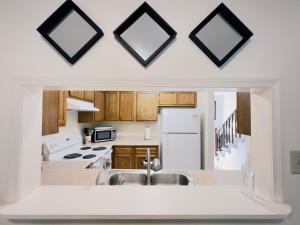 a kitchen with white appliances and wooden cabinets at Emerald Coast Vacation Destination in Pensacola