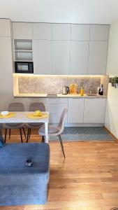 une cuisine avec une table, des chaises et un comptoir dans l'établissement Apartamentai Vetrungiu g 3, à Nido
