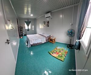 1 dormitorio con 1 cama y alfombra verde en Laman Abah Staycation, en Jenjarum