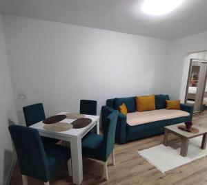 a living room with a blue couch and a table at Mediterano Apartments in Ulcinj