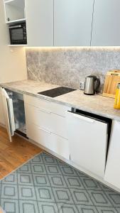 a kitchen with white cabinets and a counter top at Apartamentai Vetrungiu g 3 in Nida +18 photos