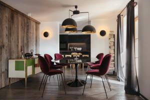 a dining room with a table and red chairs at The Grey Lodge at Bosco Verde in San Cassiano