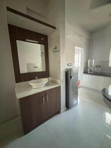a bathroom with a sink and a mirror and a refrigerator at G3 Gayathri Enclave Fully furnished 2BHK Apartment in Trivandrum