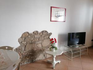 a living room with a stone wall and a tv at LA CASA DI MARZIA in Bardolino