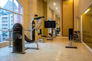 Grande Caribbean - 1 BR Apartment, 8th Floor #A815 في جنوب باتايا: صالة ألعاب رياضية مع آلات للأقدام وتلفزيون بشاشة مسطحة