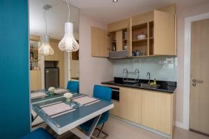 Grande Caribbean - 1 BR Apartment, 8th Floor #A815 في جنوب باتايا: مطبخ وغرفة طعام مع طاولة وكراسي