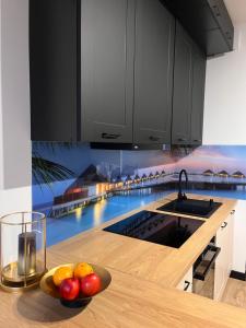 a kitchen with a bowl of fruit on a counter at Apartament Juleczka in Biała Podlaska
