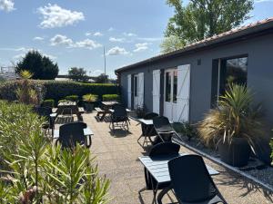 a patio with tables and chairs and plants at Kyriad Bordeaux Lormont in Lormont