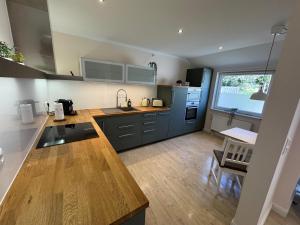 a kitchen with blue cabinets and a large window at Ferienhaus Maja in Kiel