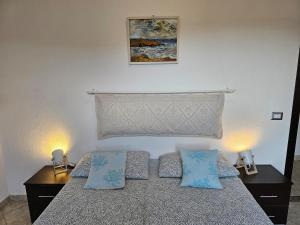 a bedroom with a bed with two blue pillows at Casa Pellegrino in Solità