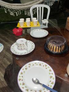 a table with plates and a cake on it at Casa ao ar livre in Aracaju +15 photos