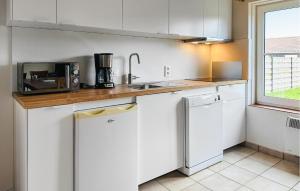 a kitchen with white cabinets and a counter top at Zeepolder Ref 230 in De Haan