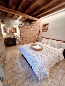 ein Schlafzimmer mit zwei Betten und einer Ziegelwand in der Unterkunft Casa-Museo La Casita de Albino in Castillo de Bayuela + 49 Fotos