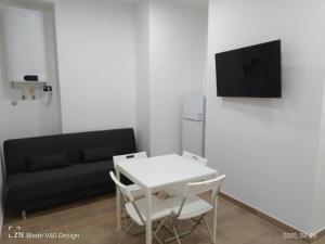 sala de estar con mesa blanca y sofá negro en Maison Cleo, en Torre Annunziata
